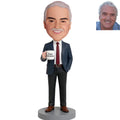 Custom male retirement bobblehead in navy suit with red tie holding Happy Retirement mug – personalized retirement gift for him handcrafted from photo