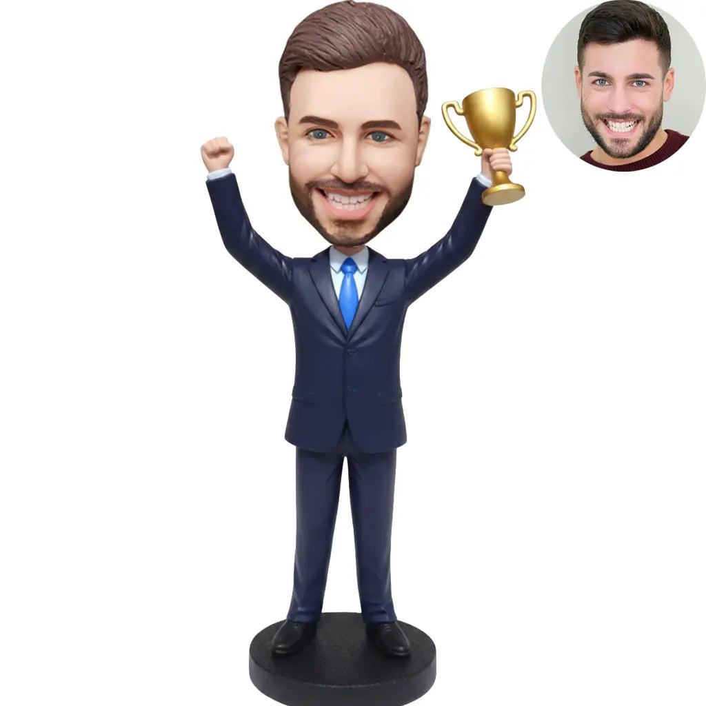Custom bobblehead for men in navy suit holding gold trophy with arms raised in victory – personalized winner boss gift handcrafted from photo