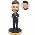 Custom male doctor bobblehead from photo wearing navy medical scrubs with stethoscope and ID badge