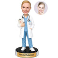 Custom female pediatrician bobblehead in light blue medical scrubs and white coat holding a clipboard