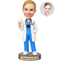 Custom female dentist thank you bobblehead in blue scrubs and white coat holding a tooth model