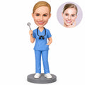 Custom female dental hygienist bobblehead in blue scrubs holding a dental mirror