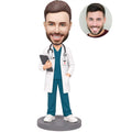 Custom male nurse practitioner bobblehead in white coat and teal scrubs holding a clipboard