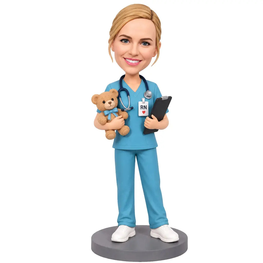 Custom female pediatric nurse bobblehead in blue scrubs holding a teddy bear and clipboard