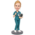 Custom female registered nurse bobblehead in teal scrubs with RN badge and patient monitor