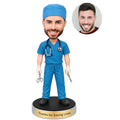 Custom male surgeon bobblehead from photo in surgical scrubs with surgical cap and instruments